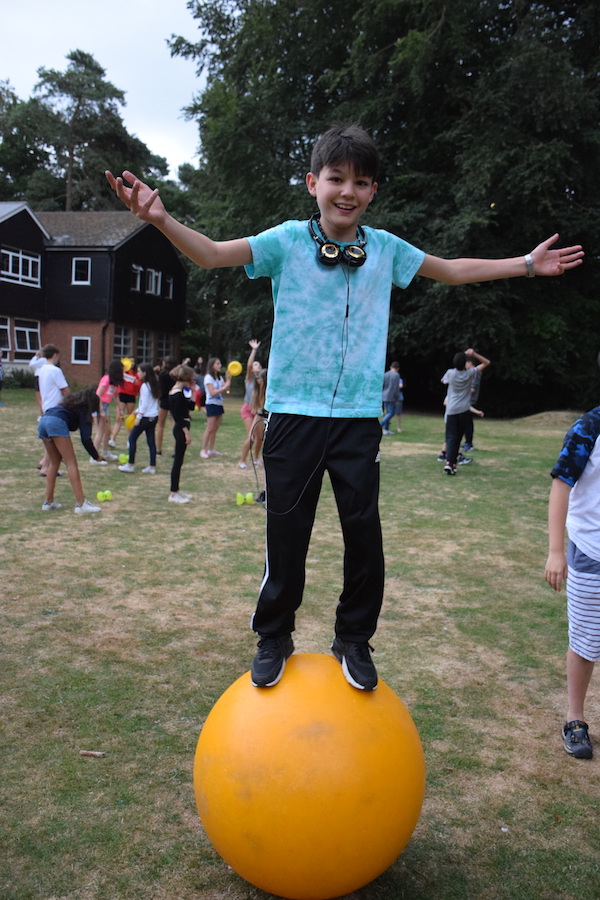 Summer junior student balancing on ball